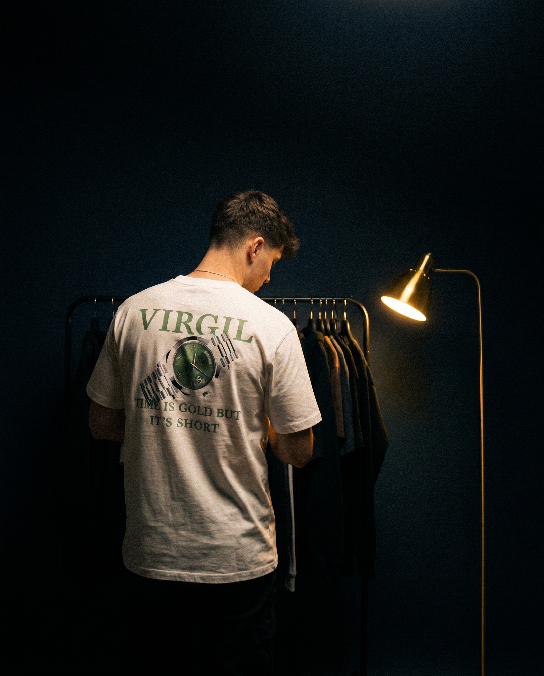 Man wearing Virgil white graphic t-shirt with Rolex print and "Time Is Gold But It's Short" text, standing by a clothing rack in a dark navy lit room — Virgil Clothing collection